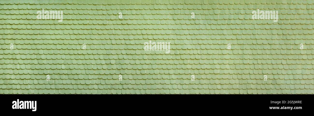 Panoramic facade made of light green painted wooden shingles Stock Photo