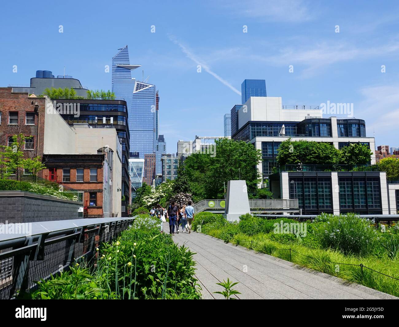 People walking the High Line in May with blooming flowers and New York ...