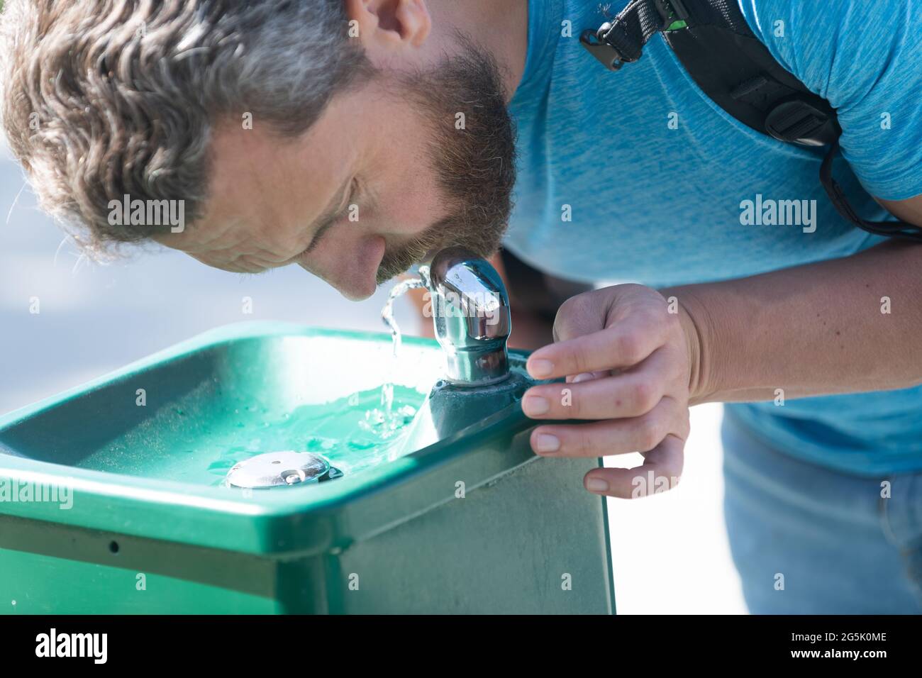 Water aid your thirst. Thirsty man. Guy drink water from drinking fountain. Thirst quenching