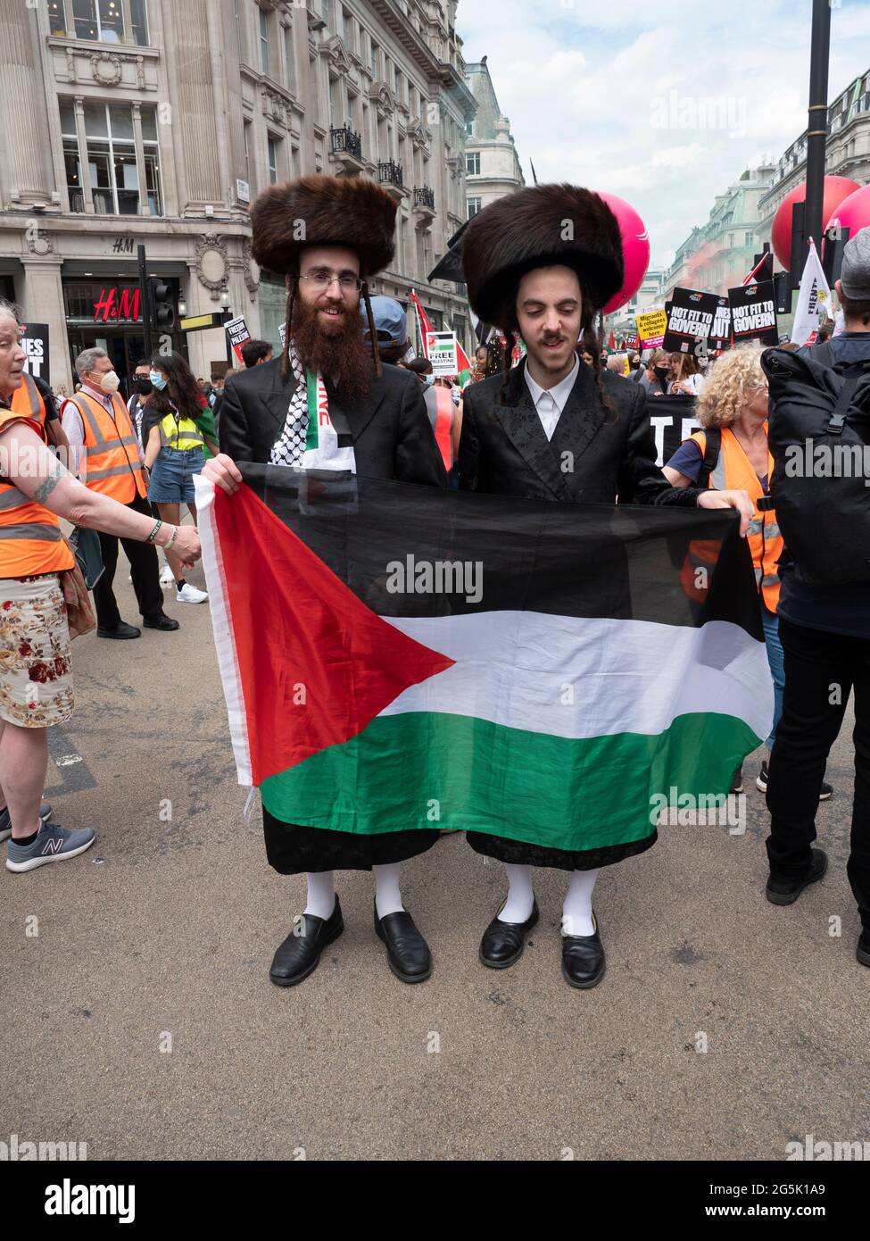 Ultra Orthodox Jews of the Neturei Karta division  from Stamford Hill who represent Orthodox Jews United Against Zionism amongst flags of Palestine attend  the People's Assembly National Demonstration in London. Rabbi Blyer is on left Stock Photo