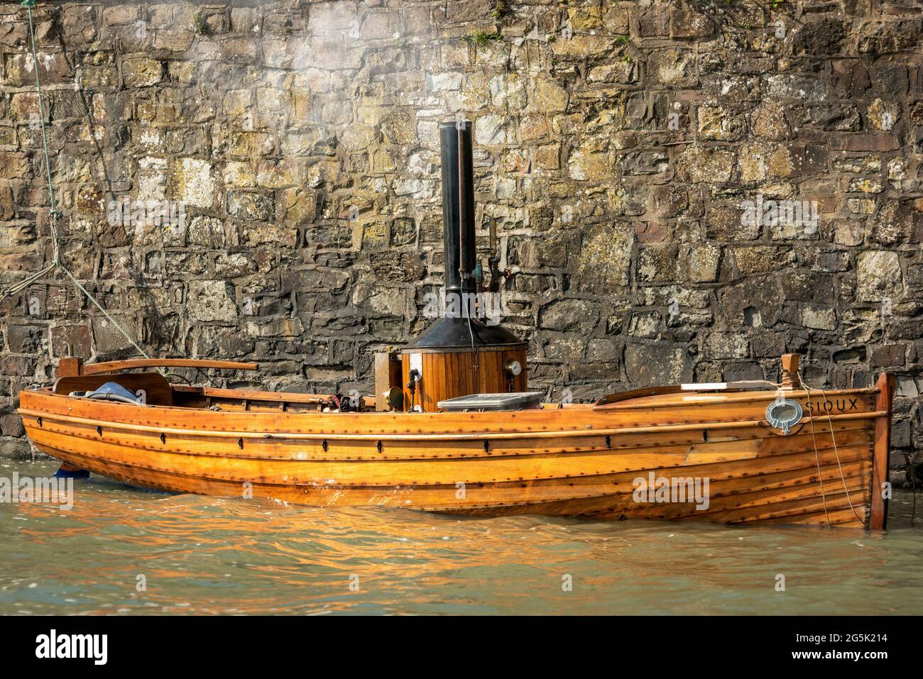 Sioux, a steam powered vintage boat, moored against the quay at Appledore in North Devon. Stock Photo