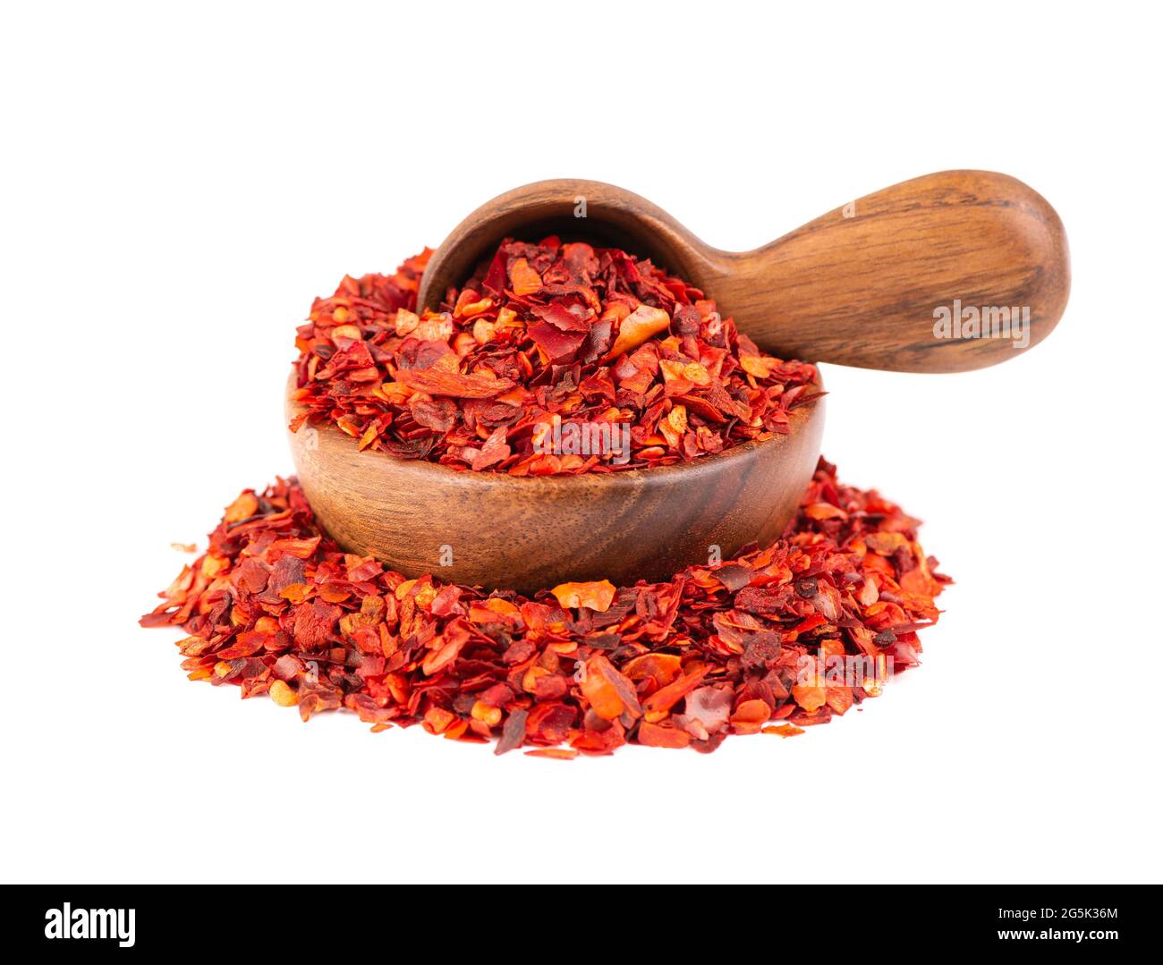 Dried red chili flakes in wooden bowl and spoon, isolated on white