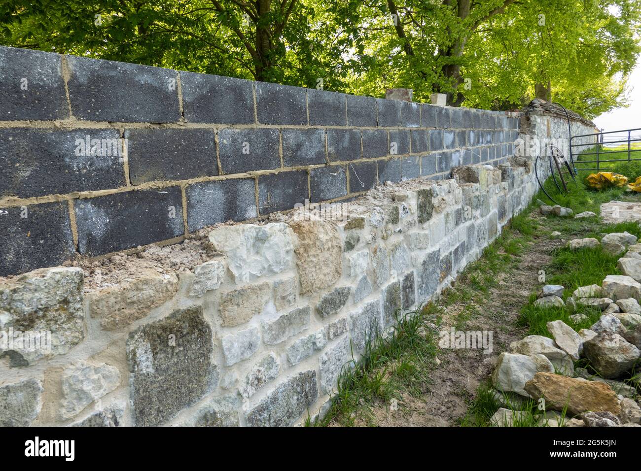 Repairing stone wall in Dorset village, Dorset, England, United Kingdom