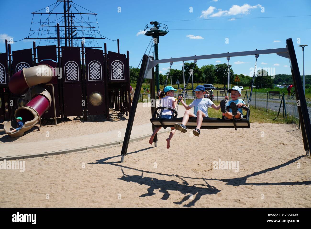 POZ, POLAND - Jun 27, 2021: Children sitting on a double seat swing set  equipment at a playground in the Malta park on a sunny day Stock Photo -  Alamy