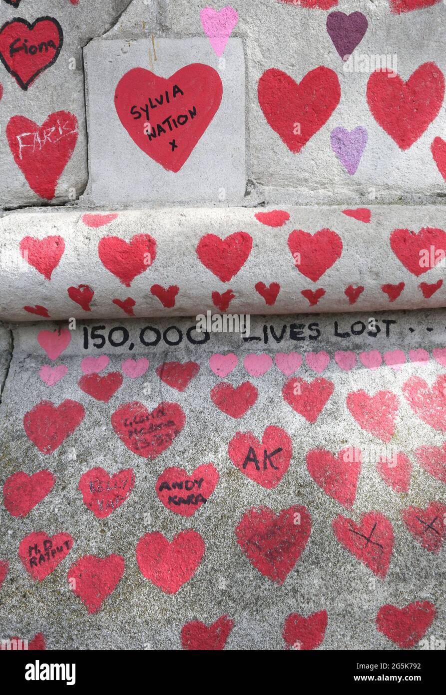 View of hearts and messages on the National Covid Memorial Wall on the embankment on the south side of the River Thames, opposite the Houses of Parliament. It provides a reminder just how tough the last year has been for many. The memorial continues to evolve - Originally one heart was drawn for each of the 150,000 people who died in the UK during the pandemic. Members of the public continue to add both hearts and personal messages as the memorial becomes a fixture of London life. Stock Photo