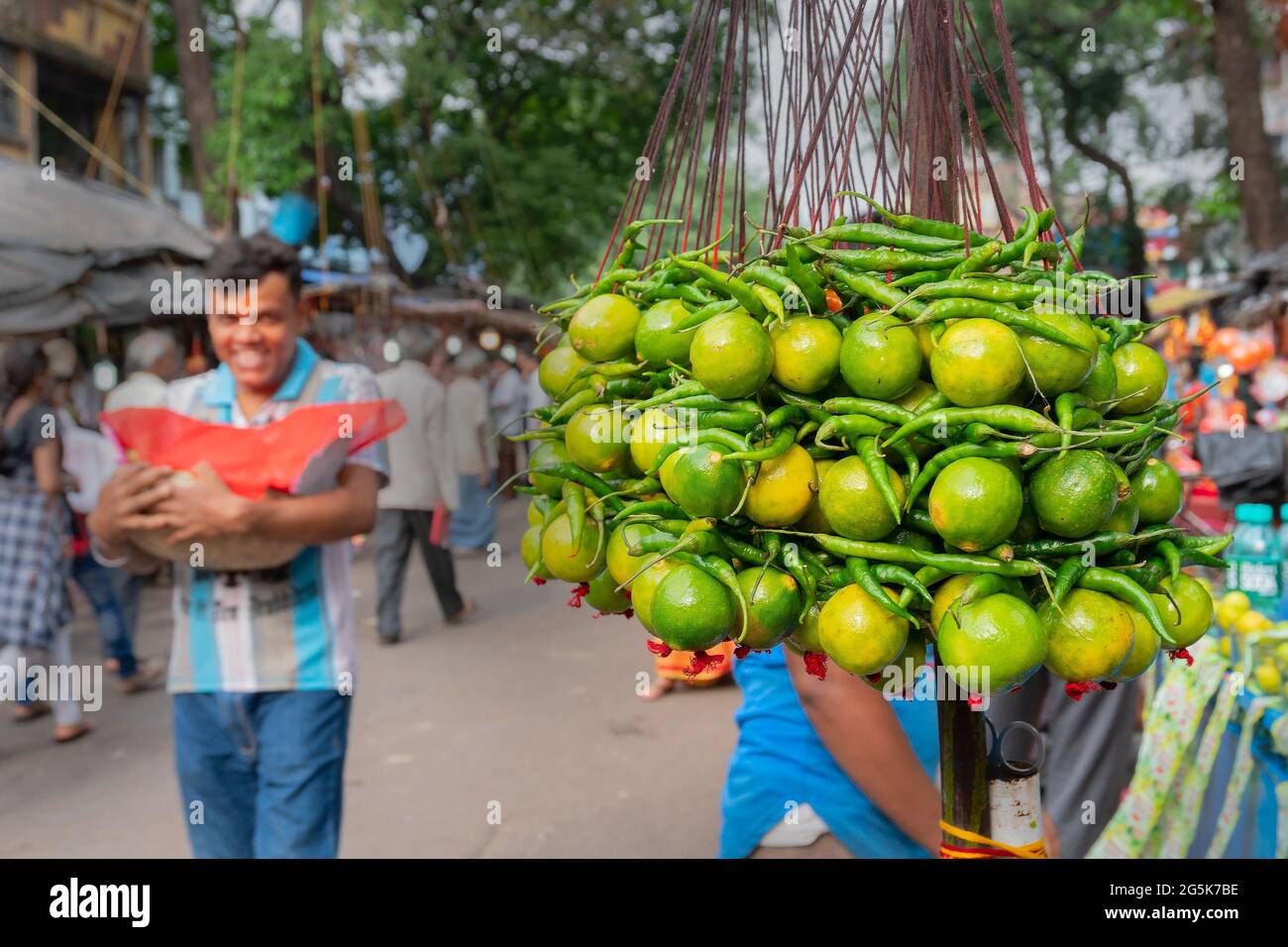 Kolkata,West Bengal, India -15th April 2019 : lemons and green chilis hanging on road for sale. Hindu religious and spiritual symbol for protection ag Stock Photo