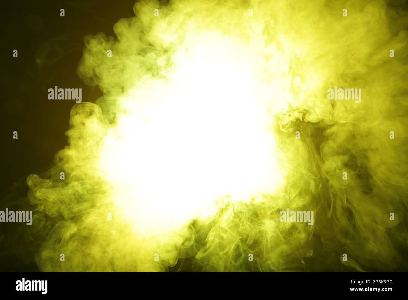 Artificial yellow light illuminates smoke on dark background Stock