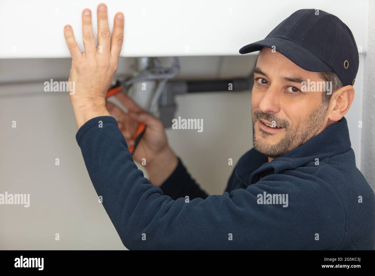 man using wrench on plumbing installation Stock Photo