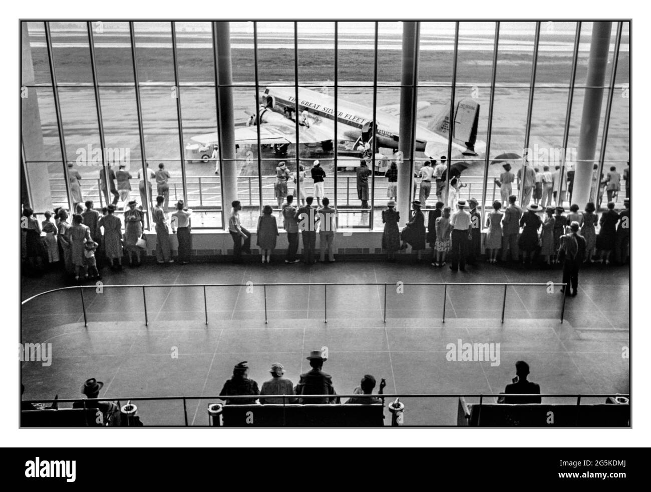 Vintage 1940s Airport Terminal Visitors watching DC3 airplane aircraft boarding activity. Seen from viewing platform at the municipal airport in Washington, D.C.] Jack Delano photographer  [1941 July]  United States--District of Columbia--Washington (D.C.) Golden age of flying.  DC3 Silver Fleet Eastern Airlines propeller aircraft outside terminal boarding passengers. Stock Photo