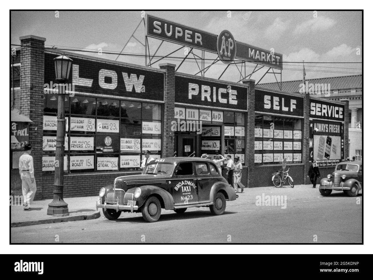 1940’s The 'super market' ‘LOW PRICE SELF SERVICE’ new shopping supermarket concept in Durham USA America. Broadway Taxi Cab outside, North Carolina America USA Jack Delano photographer 1940 May. WW2 Food shopping shops high street Main Street America Lifestyle Technology Fashion 1940’s United States--North Carolina--Durham USA Stock Photo