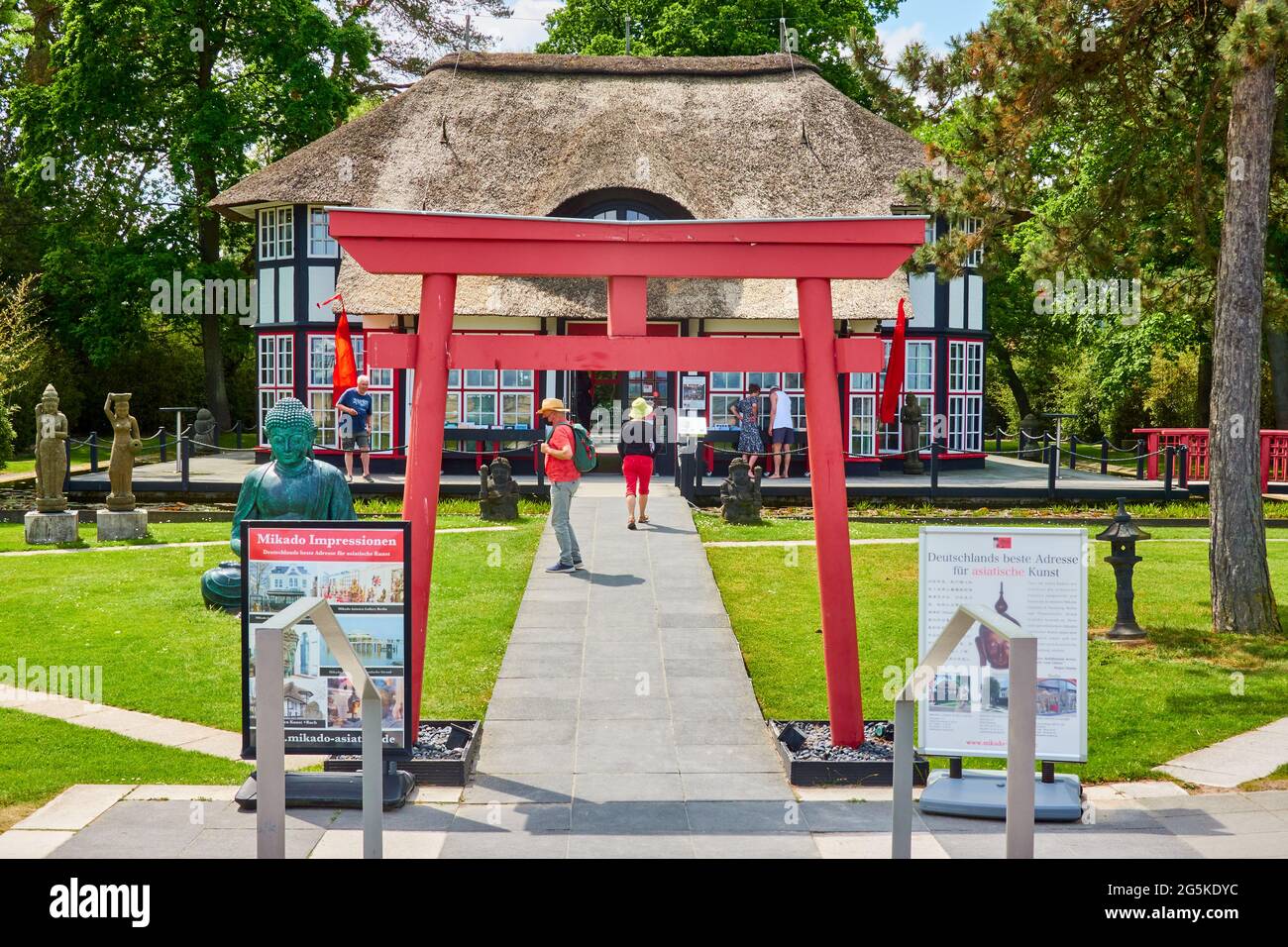 Entrance of the branch of Mikado Asiatica Gallery on Timmendorfer strand decorated with a Japanese red torii, with statues on the lawn in front of the Stock Photo