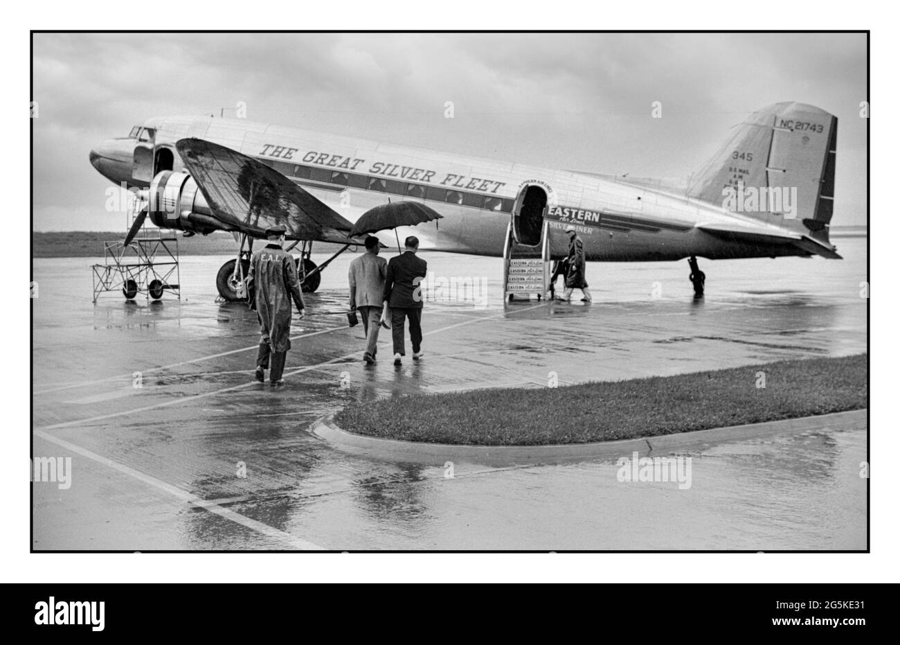 Airport 1940’s Business Travel Passengers boarding a ‘Great Silver Fleet’ DC3 Eastern Airlines propeller plane on a quiet rainy day at the municipal airport in Washington, D.C. USA  Jack Delano photographer United States. Farm Security Administration.  [1941 July] during WW2 - United States--District of Columbia--Washington (D.C.) AMERICA USA Stock Photo