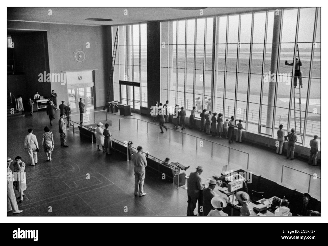 Airport Concourse Archive 1940s WW2  America Airport Airline Terminal building interior with a window cleaner up a high ladder at the municipal airport in Washington, D.C. Lifestyle in America during World War II by Jack Delano LOC War Information Photographer  [1941 July] United States--District of Columbia--Washington (D.C.) USA Stock Photo