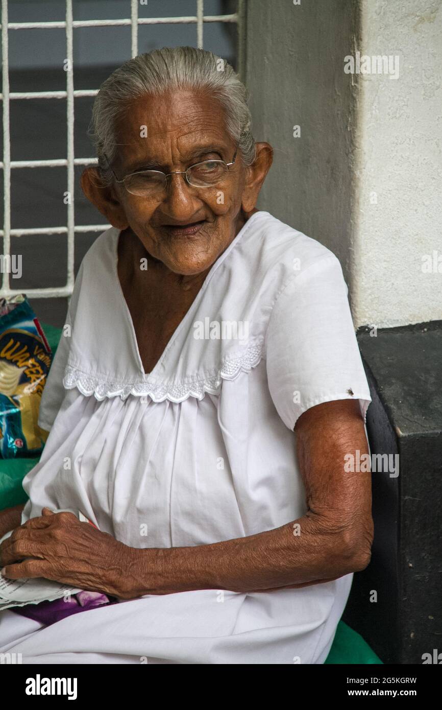 Old lady sitting outside her house, Mumbai ,India Stock Photo