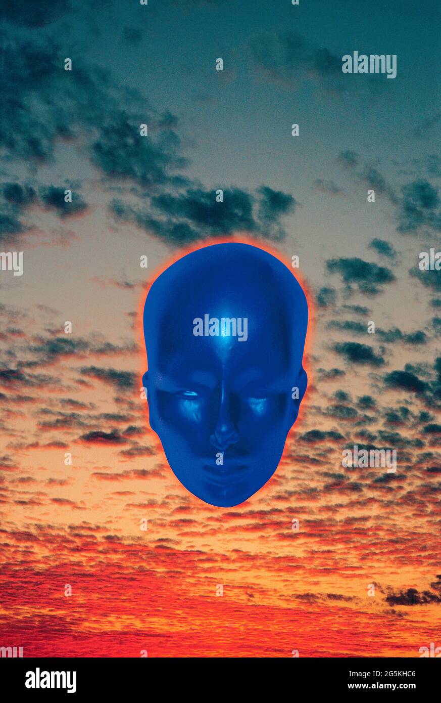 Concept. Blue head floating mid-air in sunset sky. Stock Photo