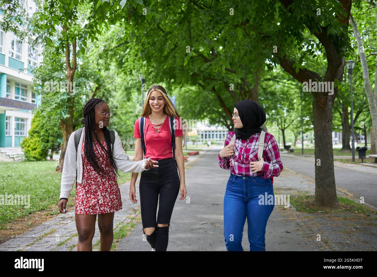Three college friends walking around campus Stock Photo