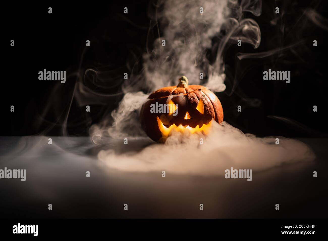 Halloween, orange pumpkin with a scary luminous face on a dark ...