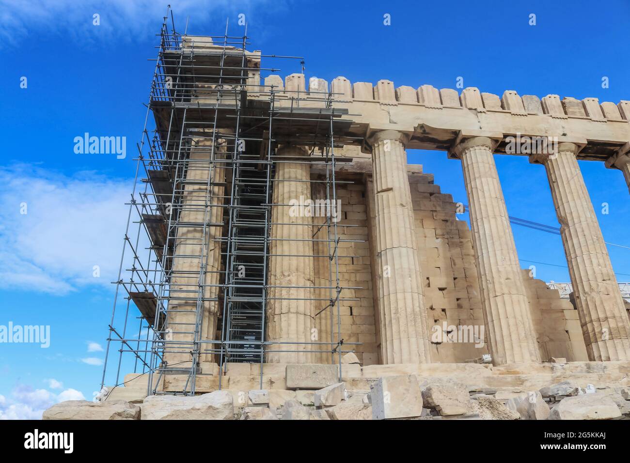The Parthenon in Athens Greece under construction with metal scaffolding - view looking up from close-up to building - beautiful blue sky Stock Photo