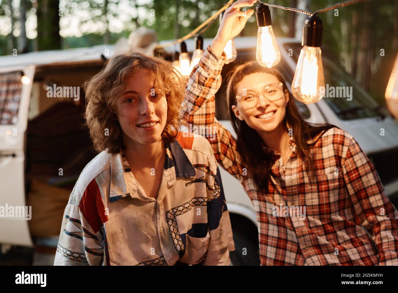 Portrait of two friends smiling at camera while having fun on a picnic outdoors Stock Photo