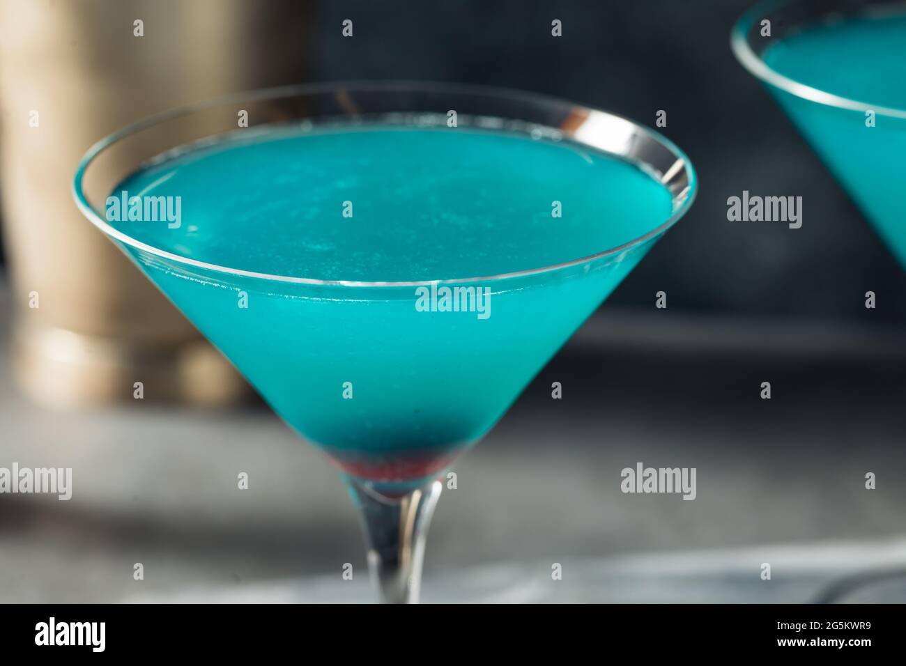 Boozy Refreshing Blue Martini Cocktail with Cherry Garnish Stock Photo