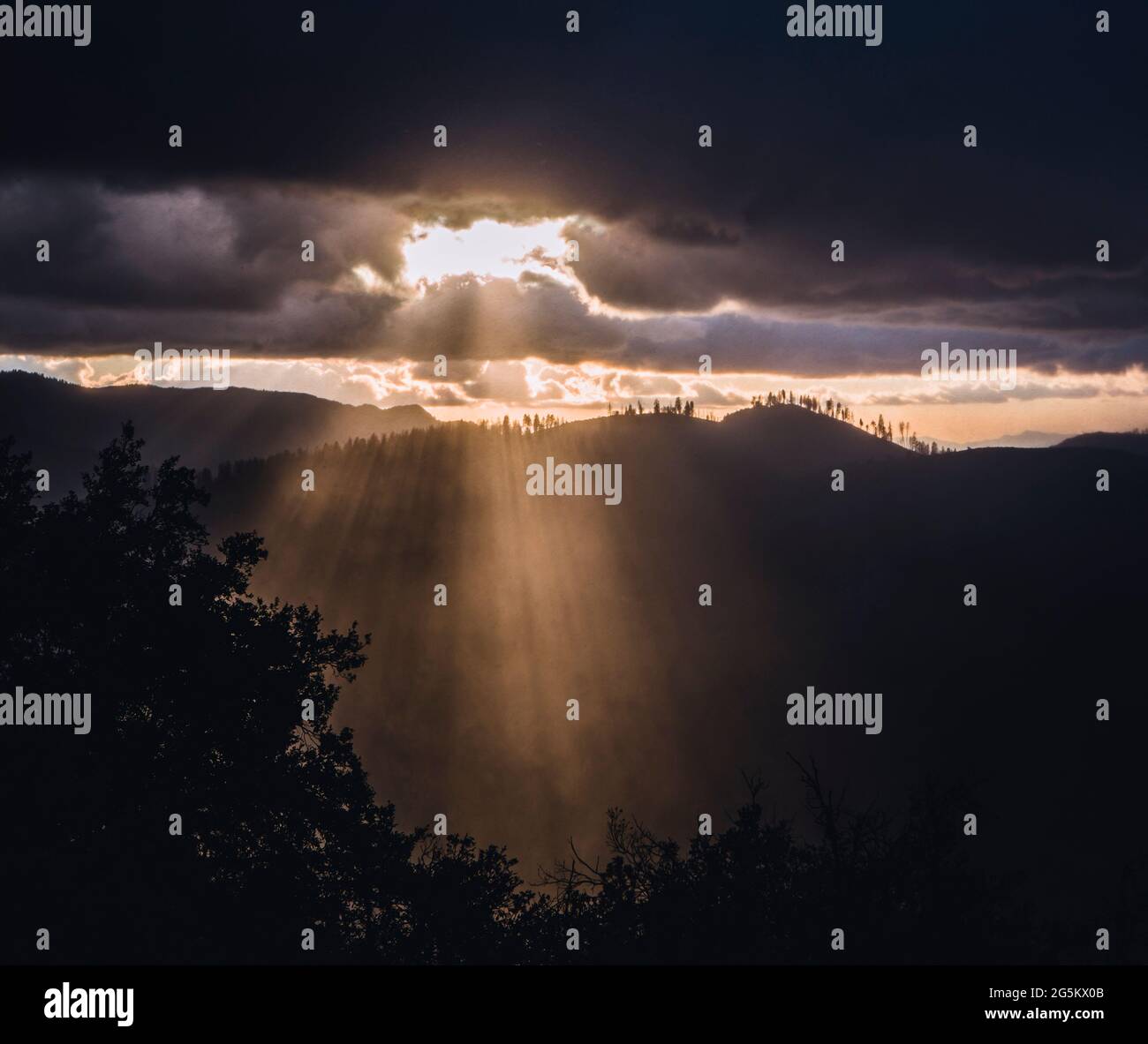 Sunlight rays burst through clouds after storm, Yosemite California Stock Photo