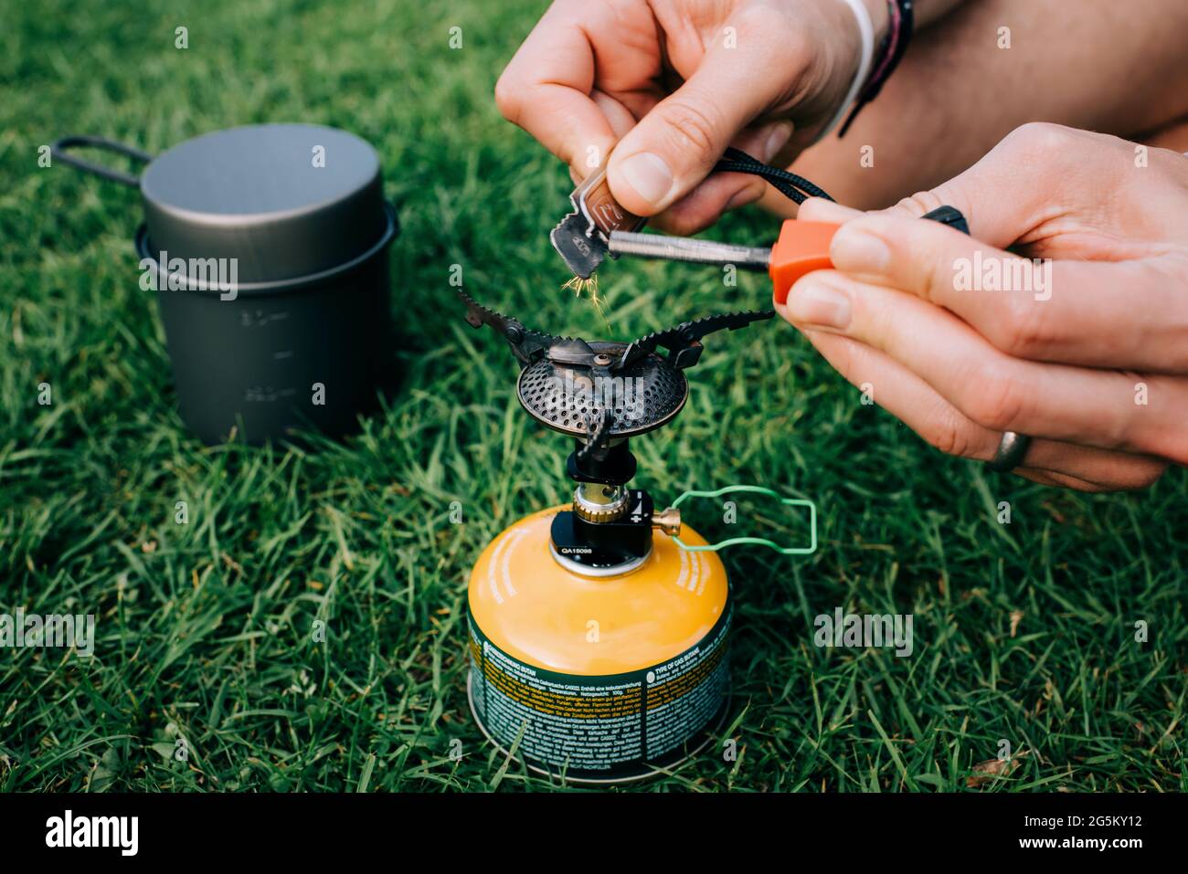 man lighting a portable stove on a campsite Stock Photo