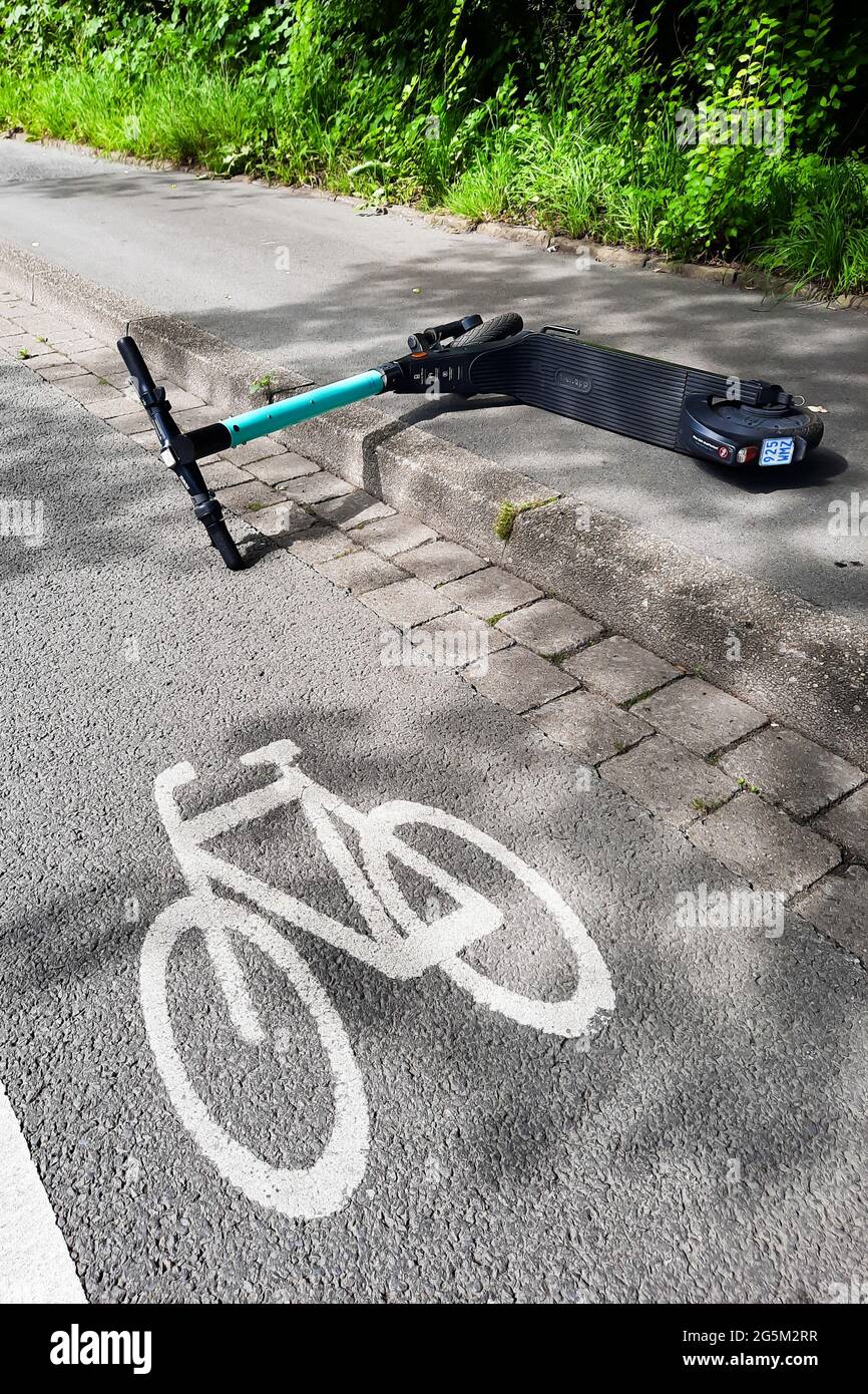 A carelessly thrown e-scooter is partly on a bike path in Dortmund, Germany  --- Ein achtlos hingeworfener e-Scooter liegt teilweise auf einem Radweg in  Dortmund, Germany Stock Photo - Alamy