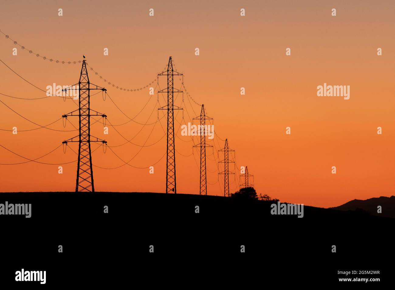 Towers of electricity over mountains at sunset. Silhouettes of power ...
