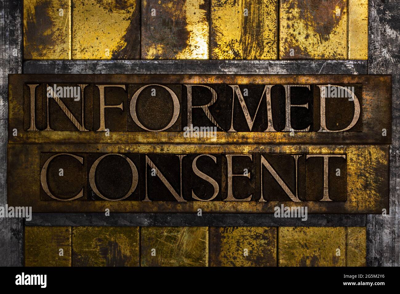 Informed Consent text formed with real authentic typeset letters on vintage textured silver grunge copper and gold background Stock Photo
