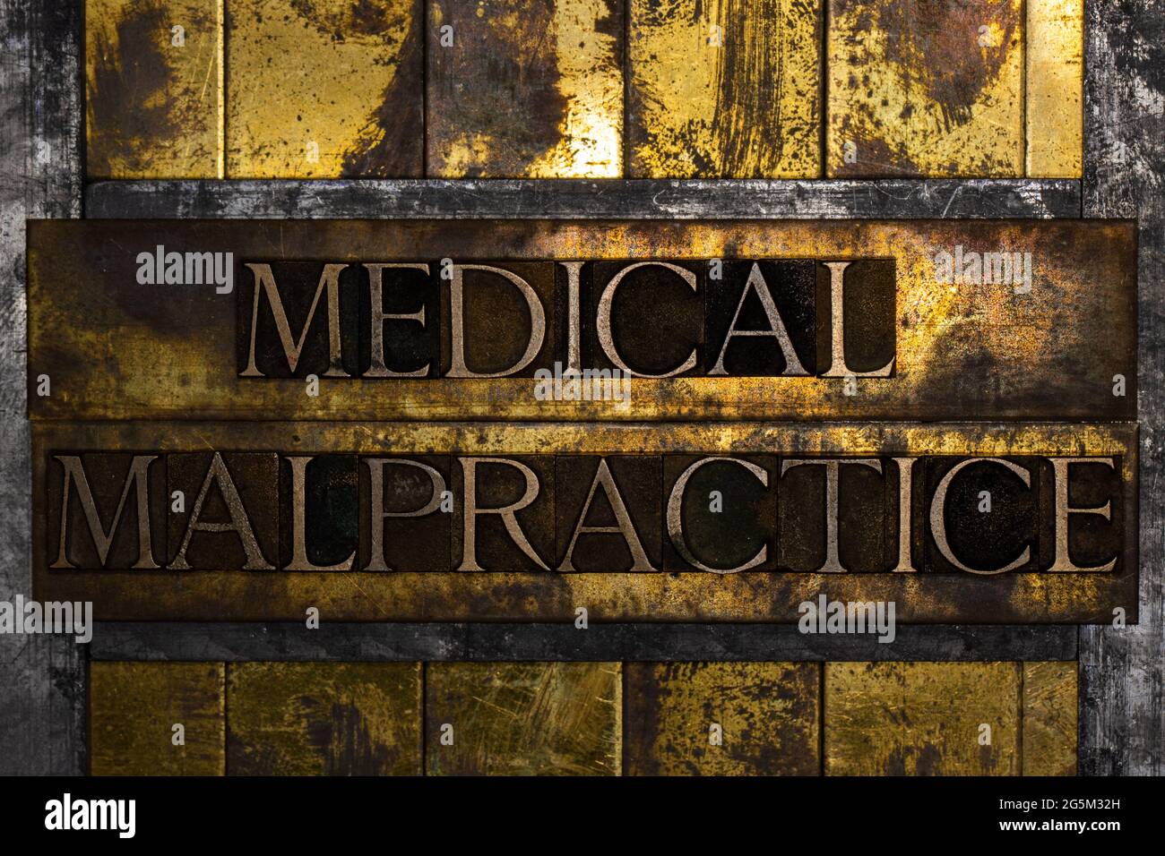 Medical Malpractice text formed with real authentic typeset letters on vintage textured silver grunge copper and gold background Stock Photo