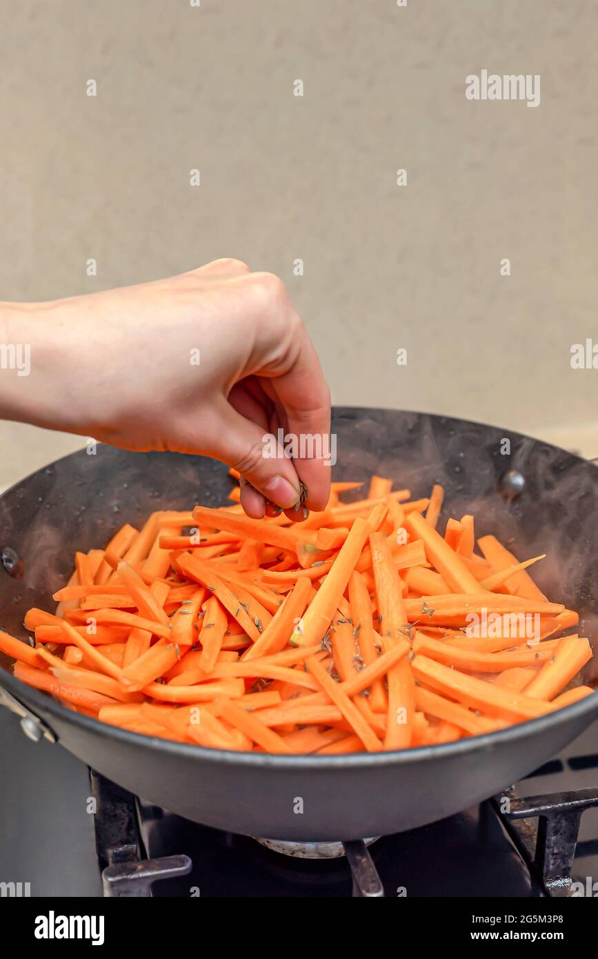 Cooking pilaf in a cauldron, a recipe for real pilaf. Sprinkle carrots with cumin, add spices to