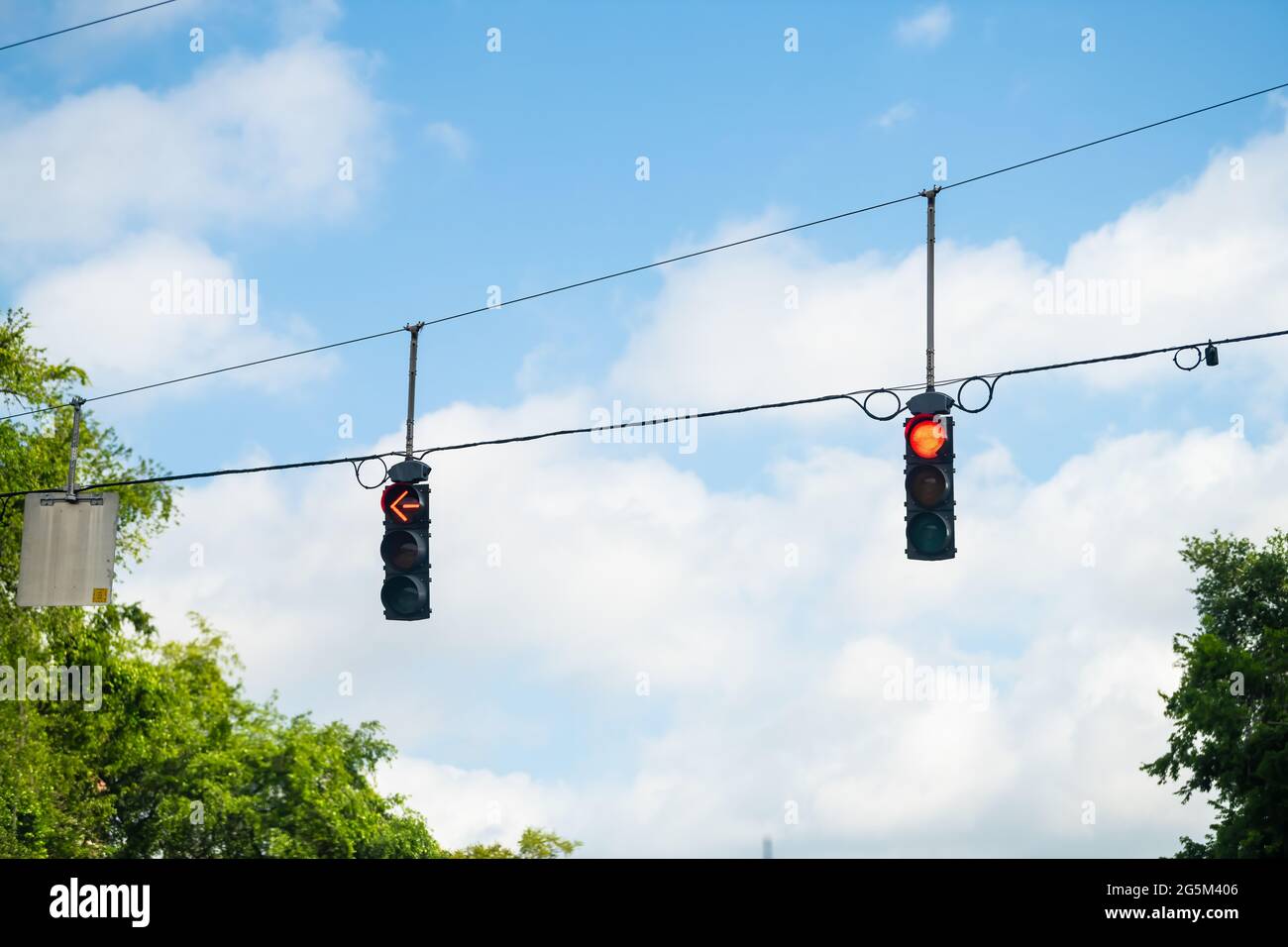 Gainesville, Florida city point of view driving with vertical road sign traffic red light signal and blue sky in background Stock Photo