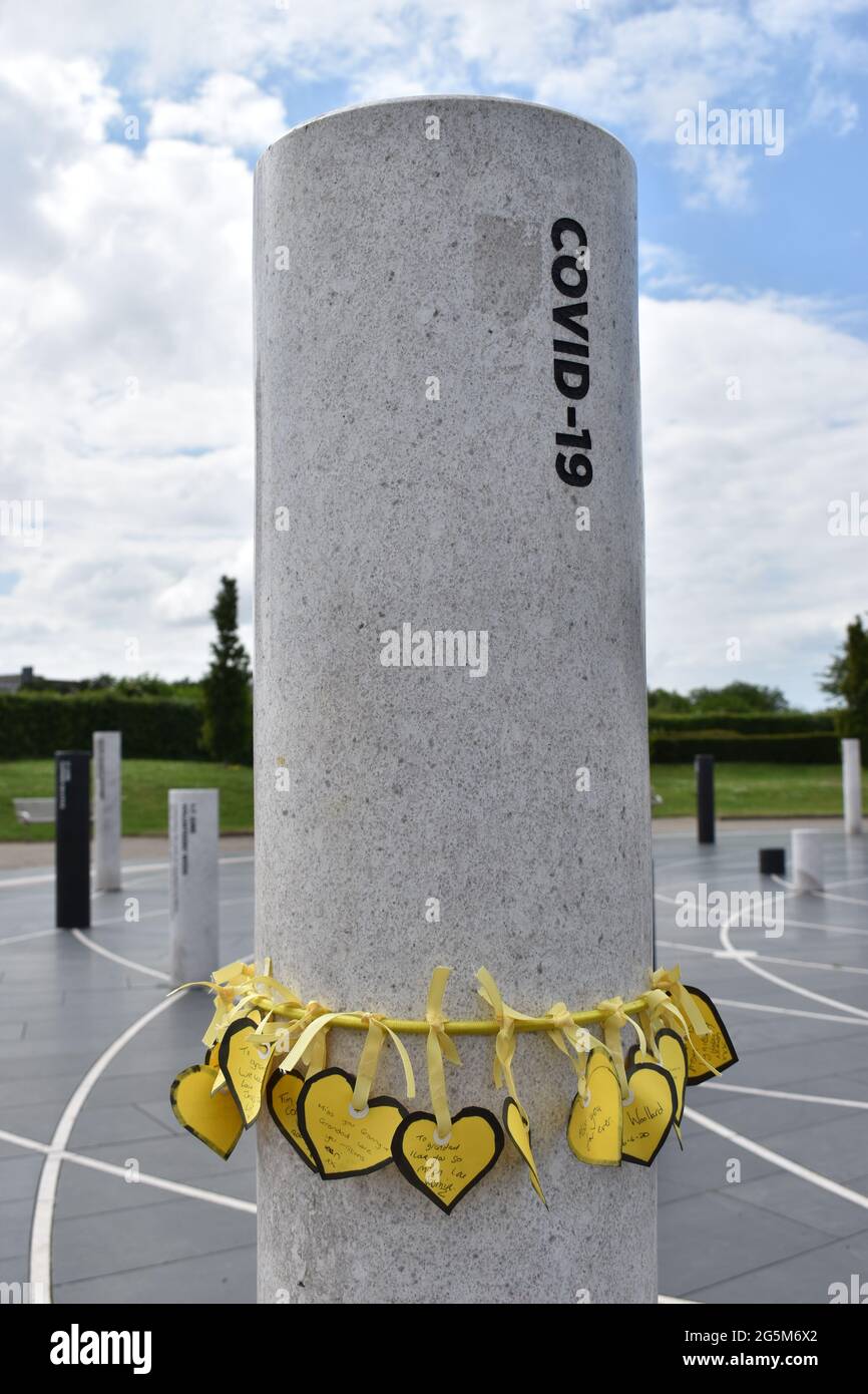 Yellow hearts to mark the loss of loved ones to COVID-19 at the memorial pillar at MK Rose in Central Milton Keynes. Stock Photo