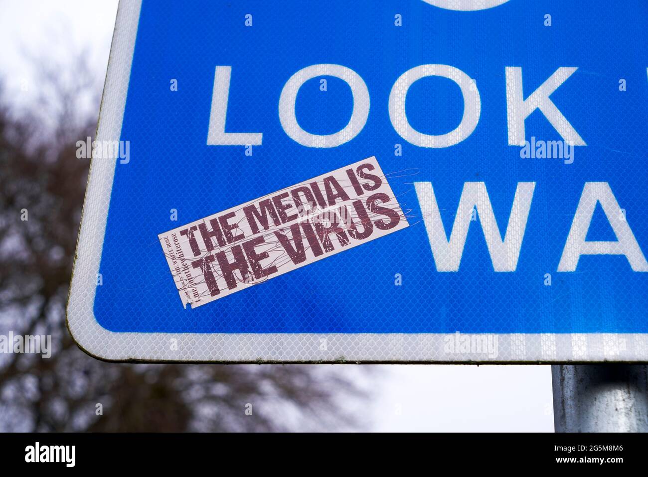 Sticker on a reflective information sign stating that the media is the virus during the Covid-19 Coronavirus pandemic published by The White Rose organisation Stock Photo