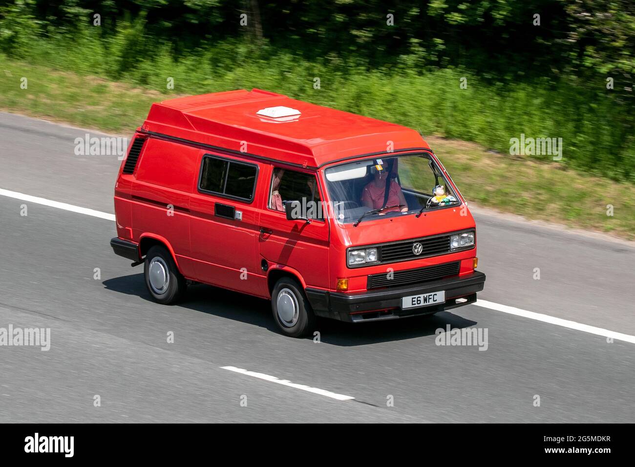 1990 90s red VW Volkswagen window panel van, 1915cc  driving on the M6 motorway near Preston in Lancashire, UK. Stock Photo