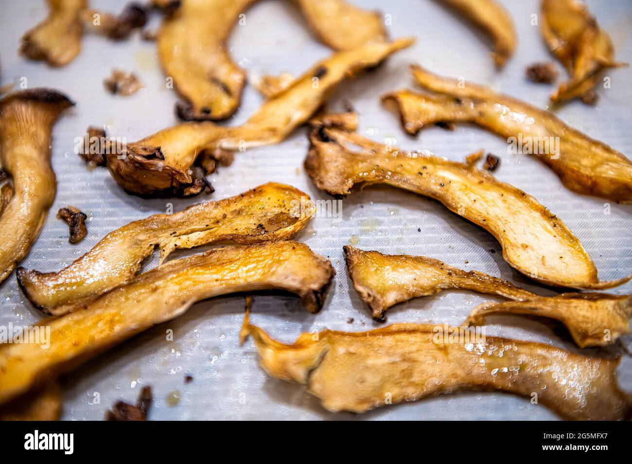 Vegan food substitution alternative for bacon or oyster mushrooms on tray drying dehydrating marinating as raw vegan food Stock Photo