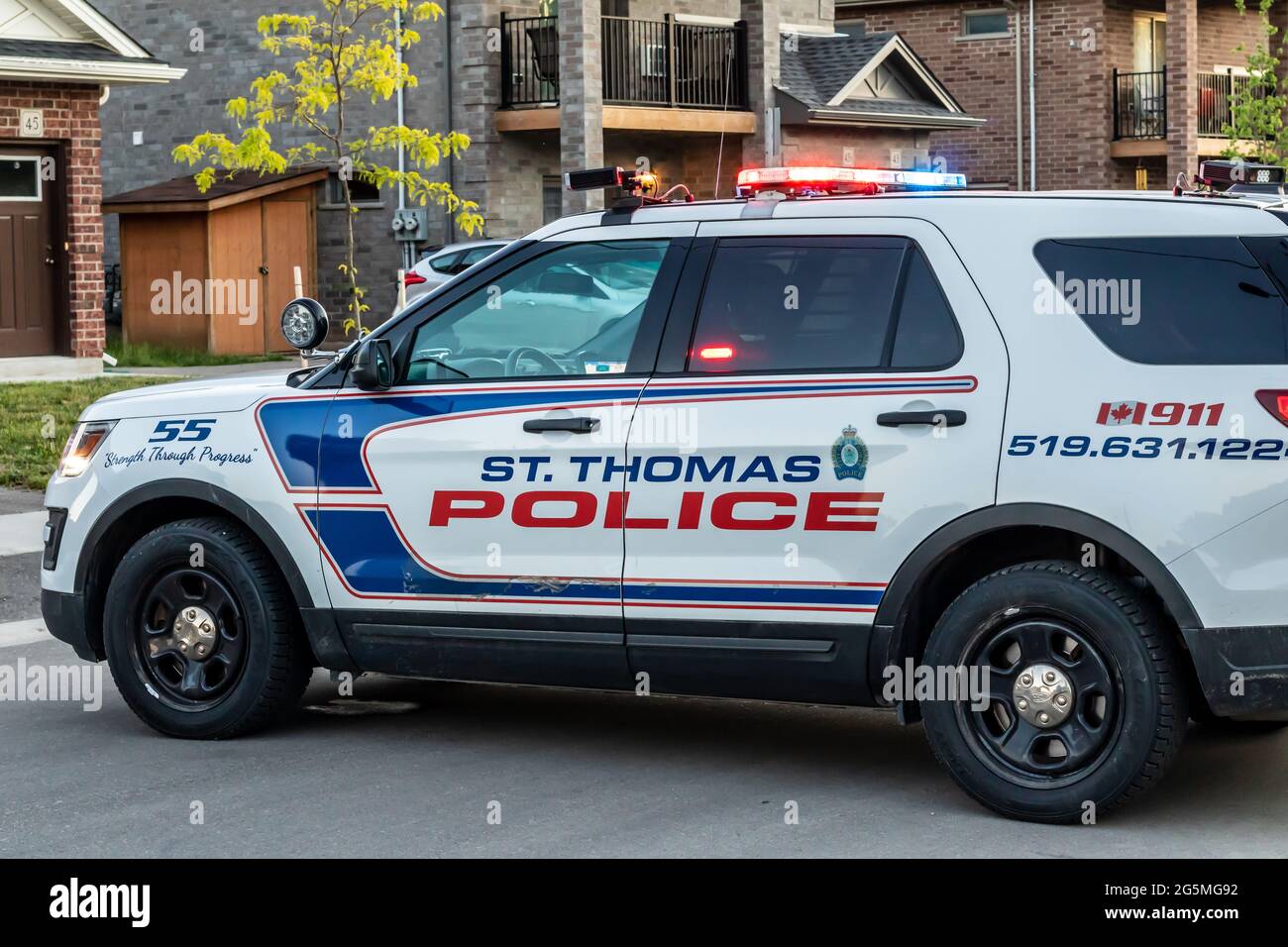 St. Thomas, Ontario, Canada - June 14 2021: St. Thomas Police cruiser vehicle parked on residential street, blocking the road, lights flashing on top. Stock Photo