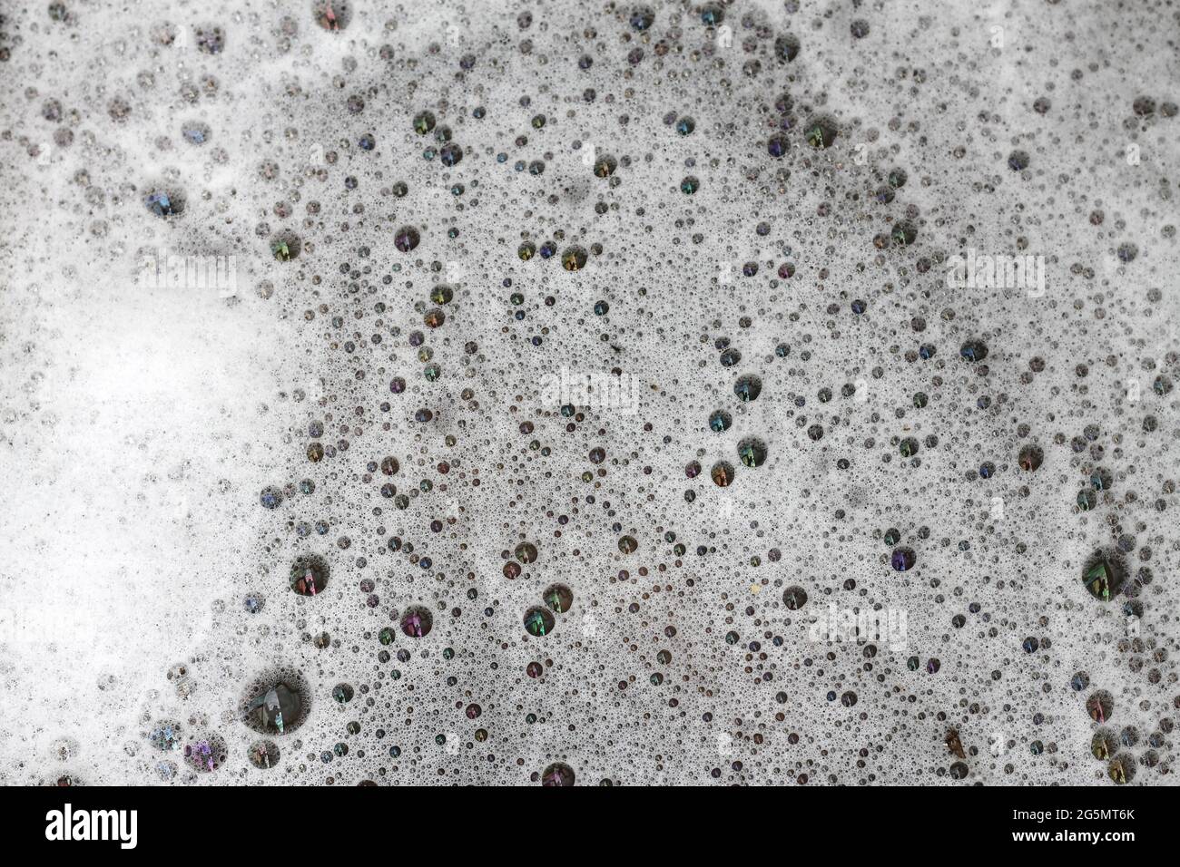 Detergent bubbles float in the waste water. Stock Photo