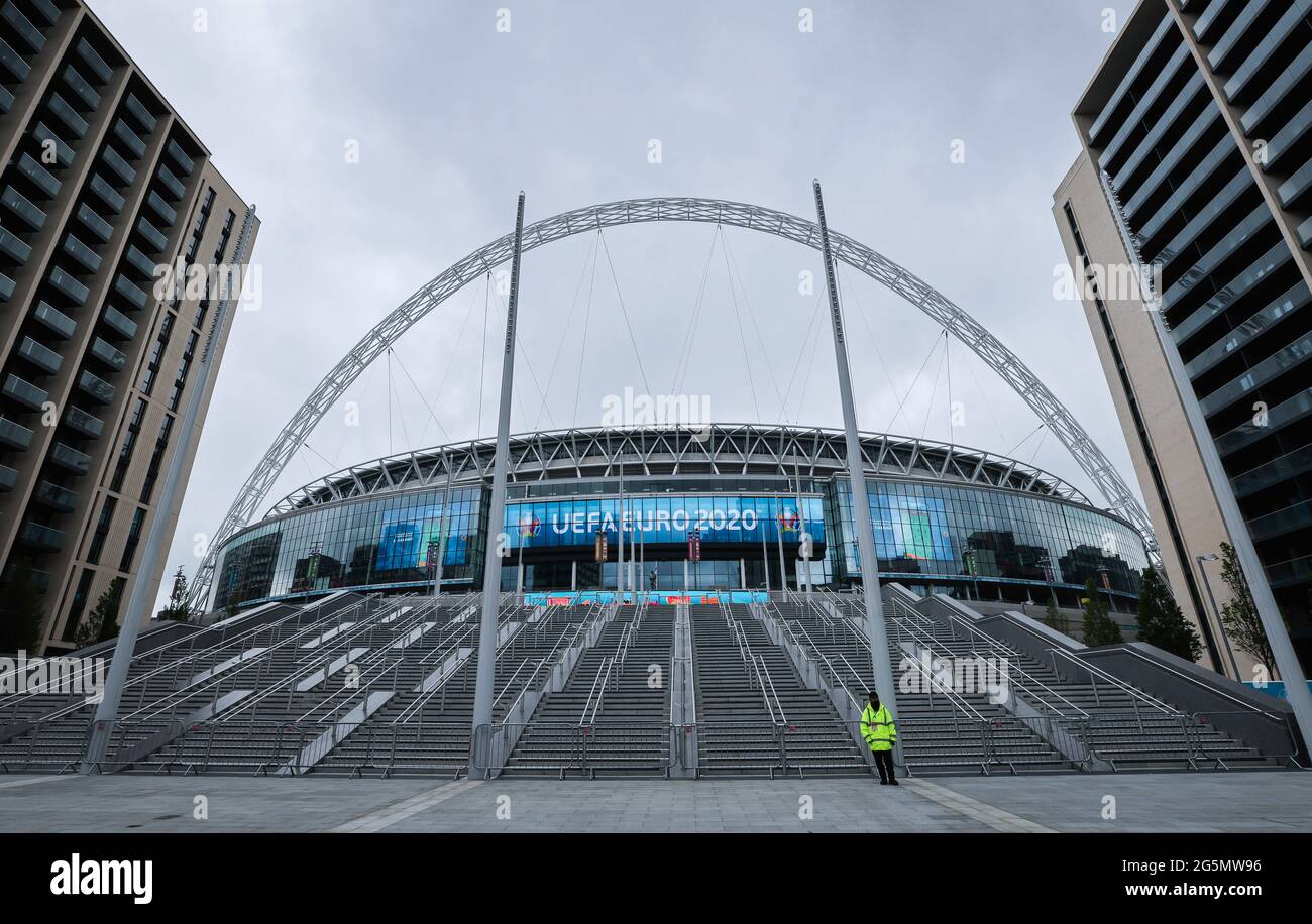 London, UK. 28th June, 2021. Football: European Championship, national team, round of 16, before the match England - Germany. A security guard is standing in front of the stairs to the main entrance of Wembley Stadium. Credit: Christian Charisius/dpa - IMPORTANT NOTE: In accordance with the regulations of the DFL Deutsche Fußball Liga and/or the DFB Deutscher Fußball-Bund, it is prohibited to use or have used photographs taken in the stadium and/or of the match in the form of sequence pictures and/or video-like photo series./dpa/Alamy Live News Stock Photo