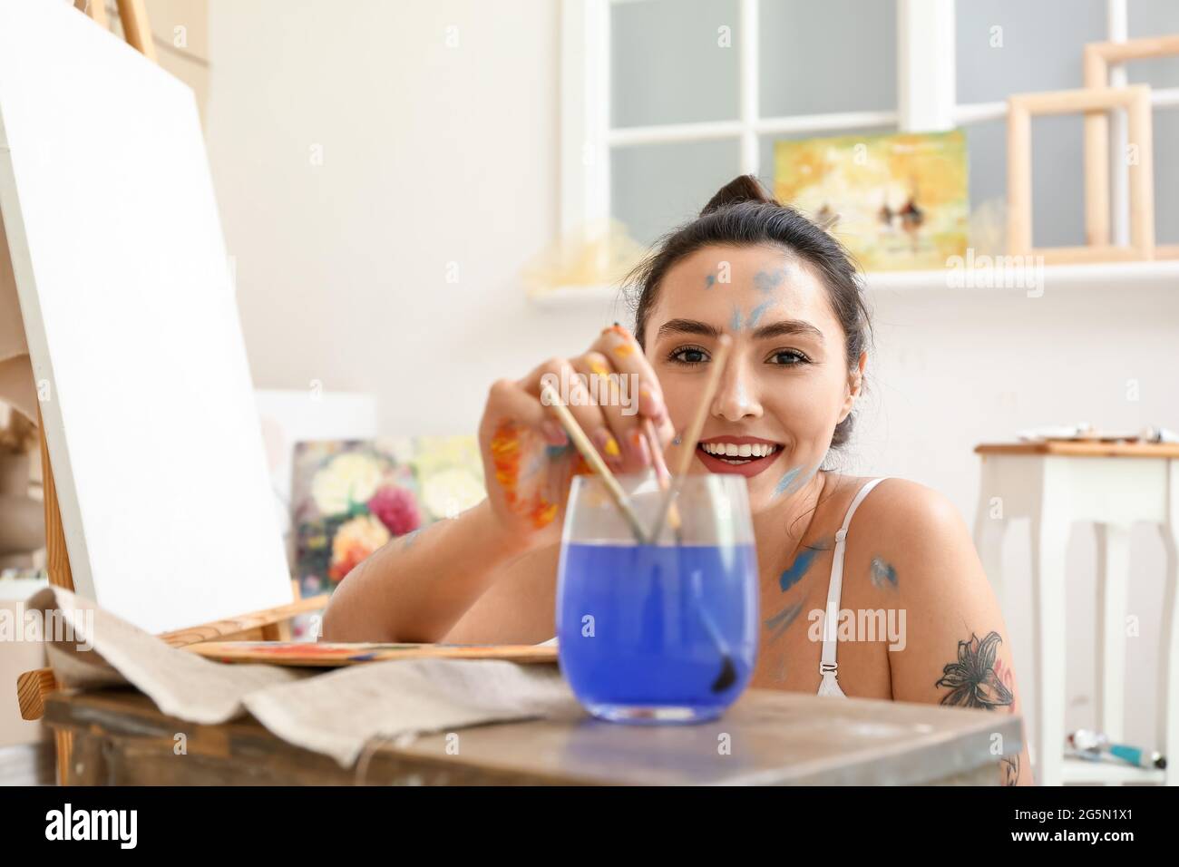 Young female artist painting in workshop Stock Photo - Alamy