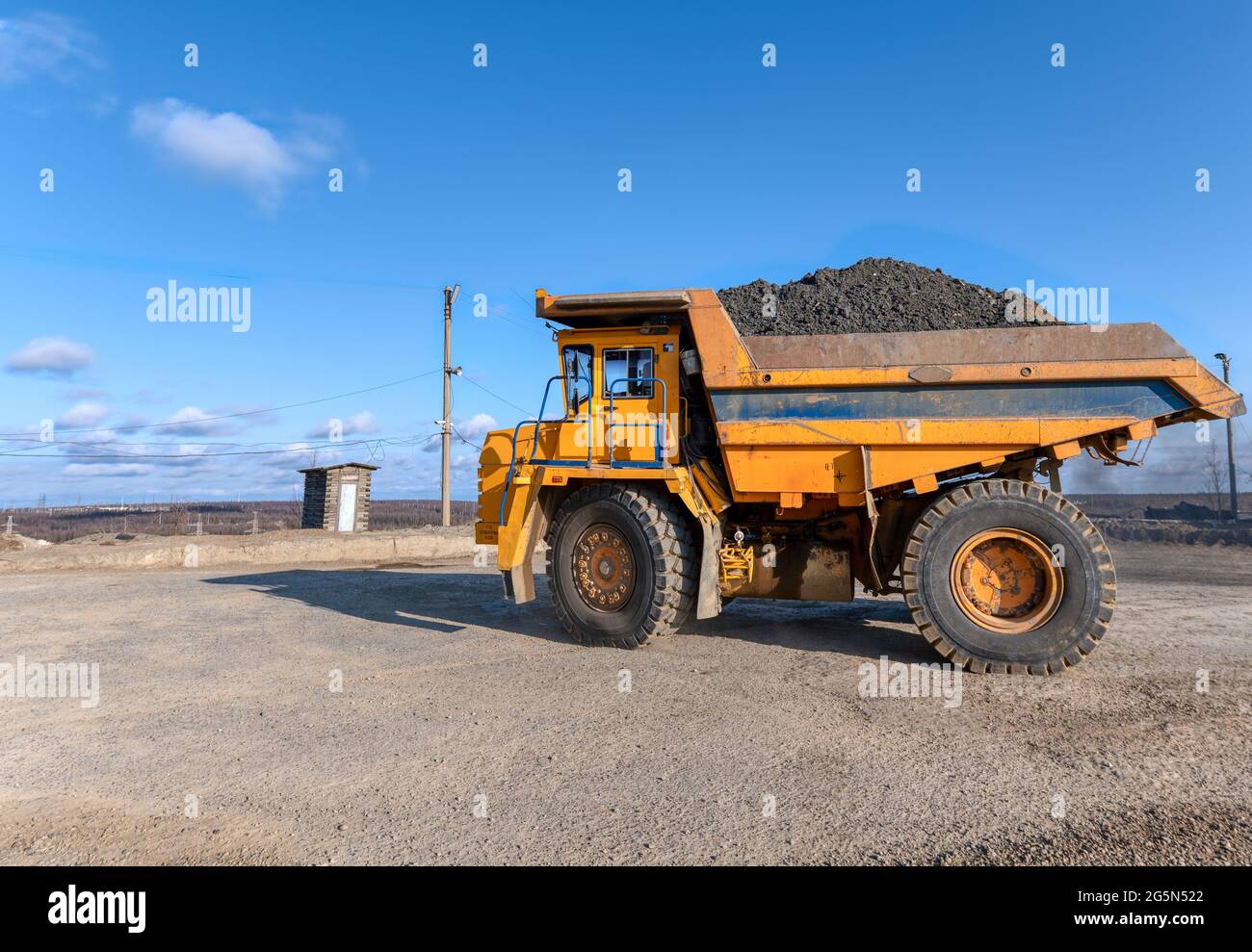 Mining truck dump truck loaded with ore. Transportation of mined ore from the open pit to the surface Stock Photo