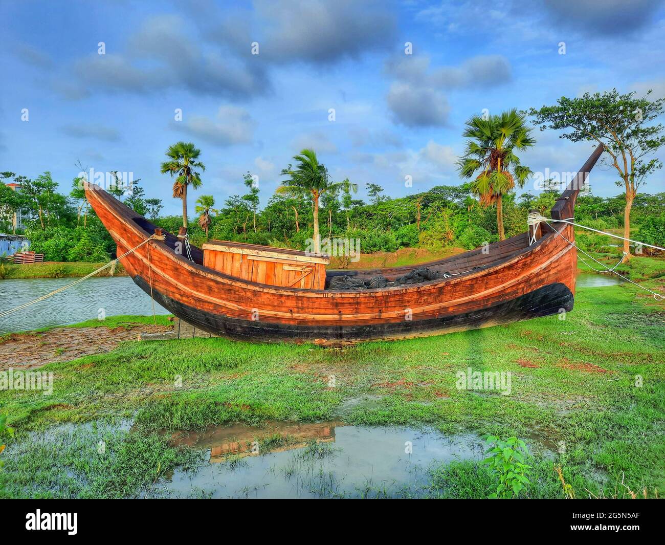 Old wooden boat moored at a field by the river Stock Photo - Alamy