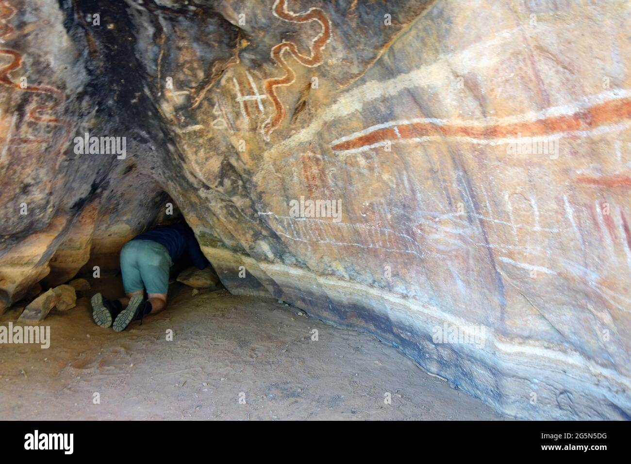 Visitor investigating Aboriginal rock art and caves at Mungana, Chillagoe-Mungana Caves National Park, Queensland, Australia. No MR Stock Photo