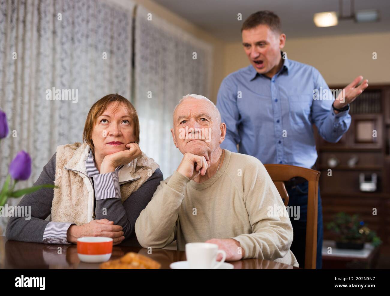 Frustrated elderly woman and man with screaming son Stock Photo - Alamy