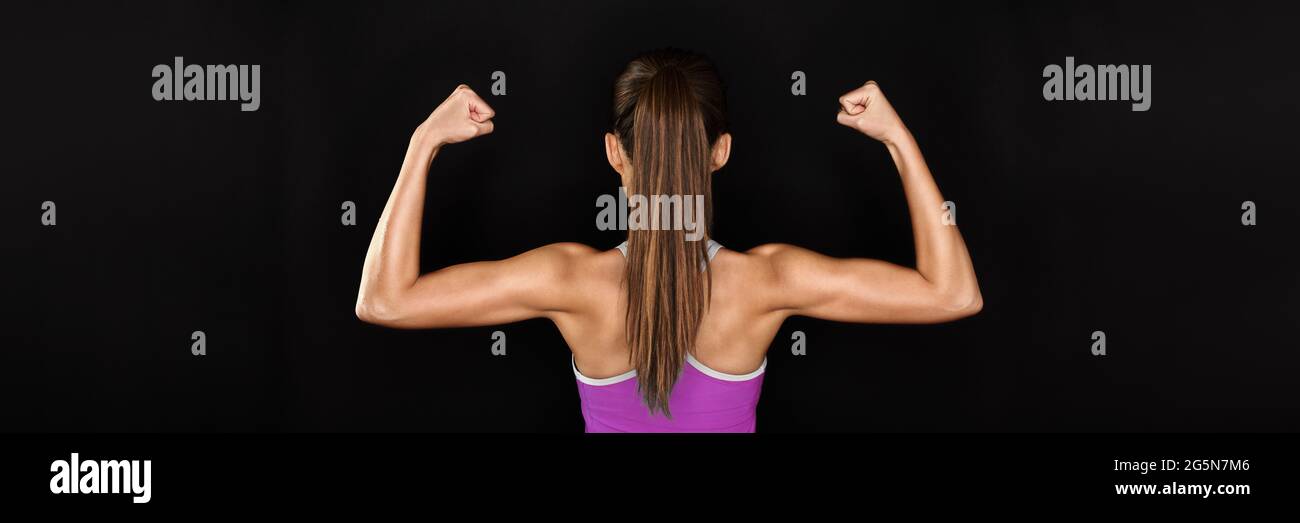 Strong fit gym woman flexing arms on black banner Stock Photo