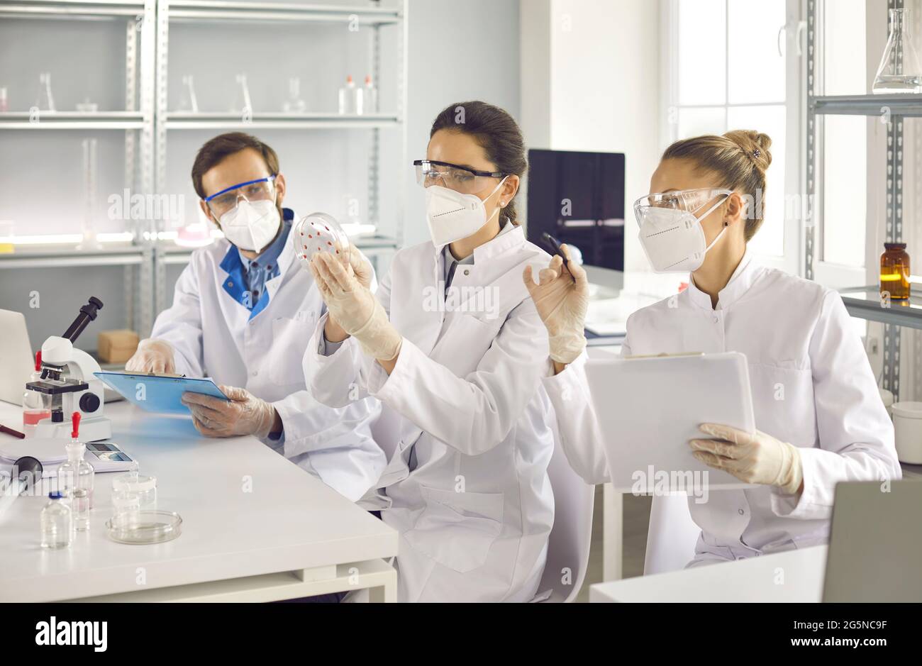 Group of scientist discussing chemical experiment results working in lab Stock Photo