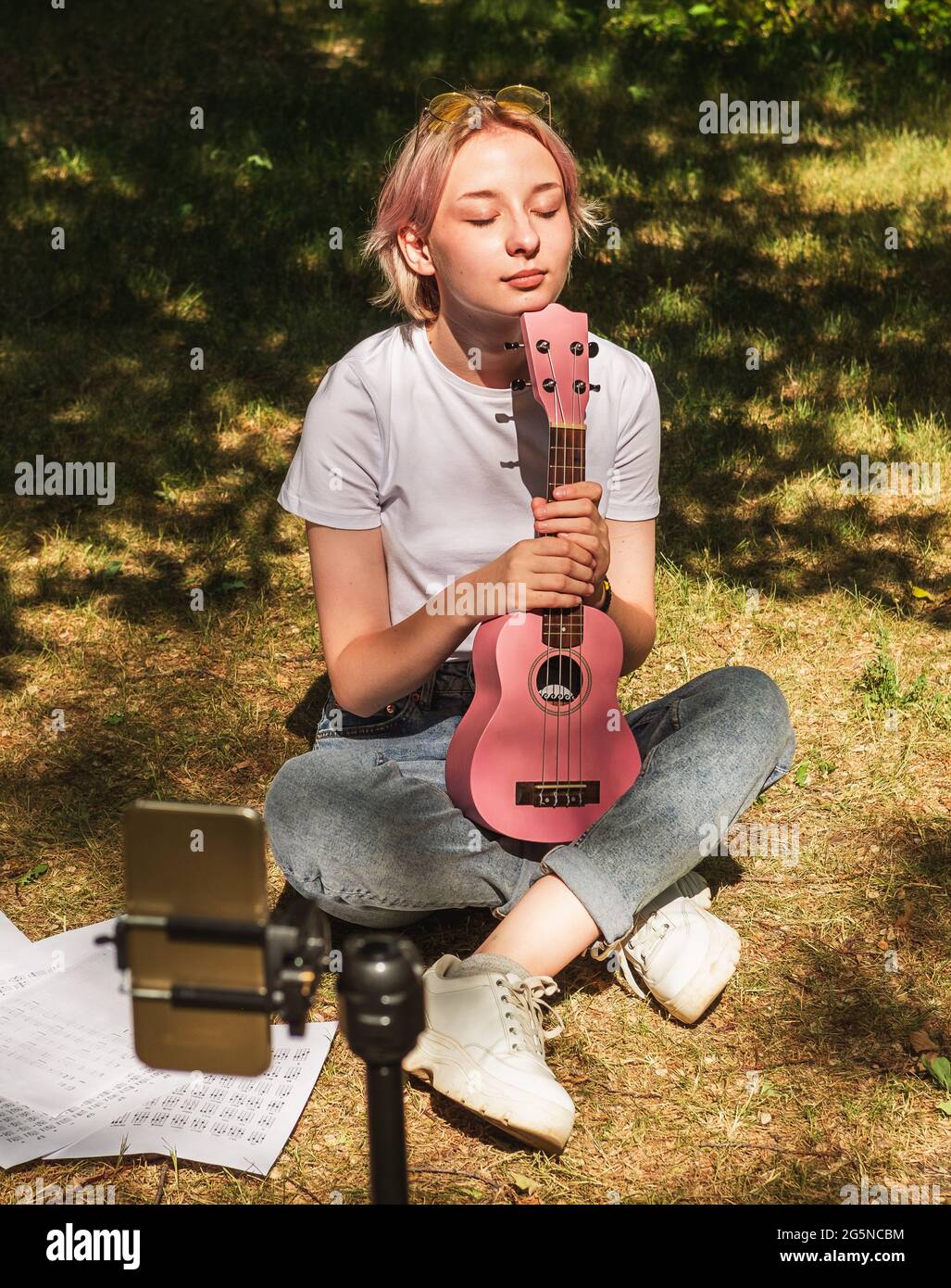 Cute teenage playing ukulele in front of camera. Online music lessons Stock Photo - Alamy