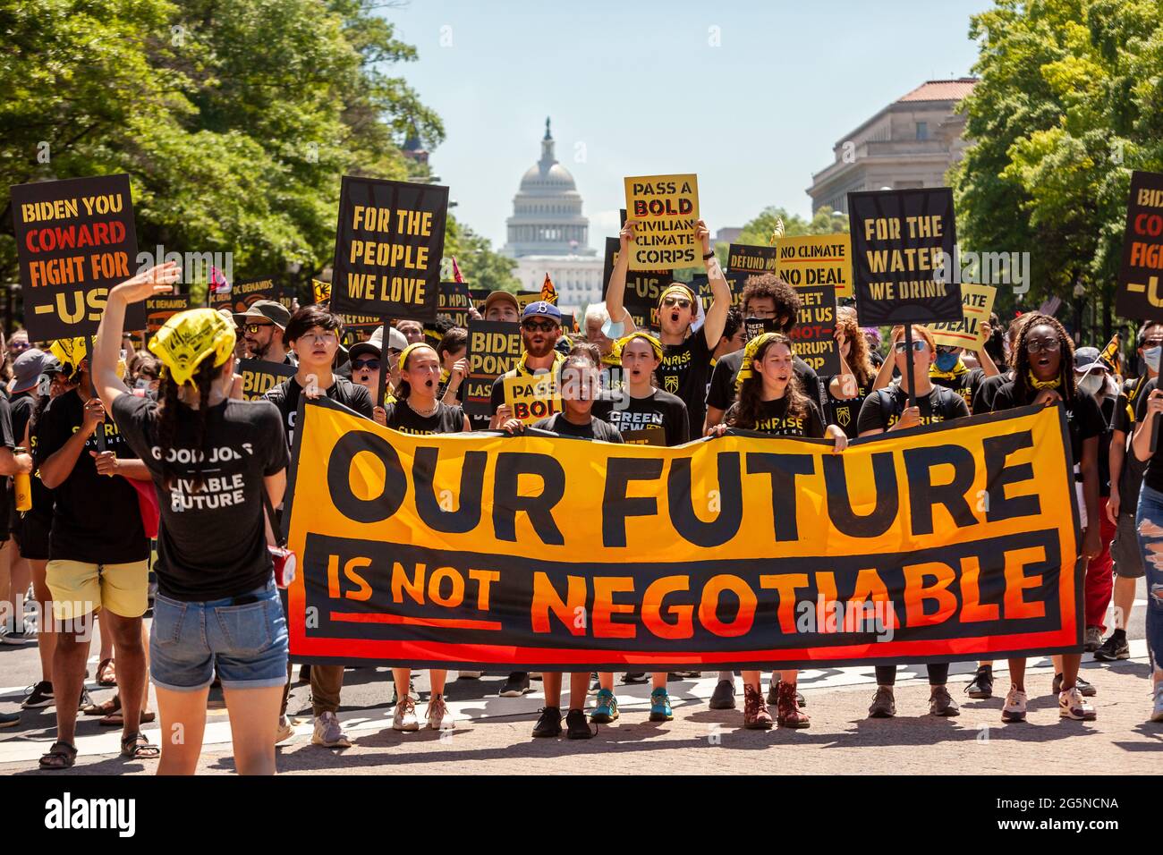 Washington, DC, USA, 28 June, 2021.  Pictured: Hundreds of protesters march down Pennsylvania Avenue, en route to the White House.  Protesters are young adults who are members of the Sunrise Movement.  They have 3 demands of the Biden Administration: no compromises on climate with Congressional Republicans, a meeting with Sunrise Movement, and the creation of a Civilian Conservation Corps.  Credit: Allison Bailey / Alamy Live News Stock Photo