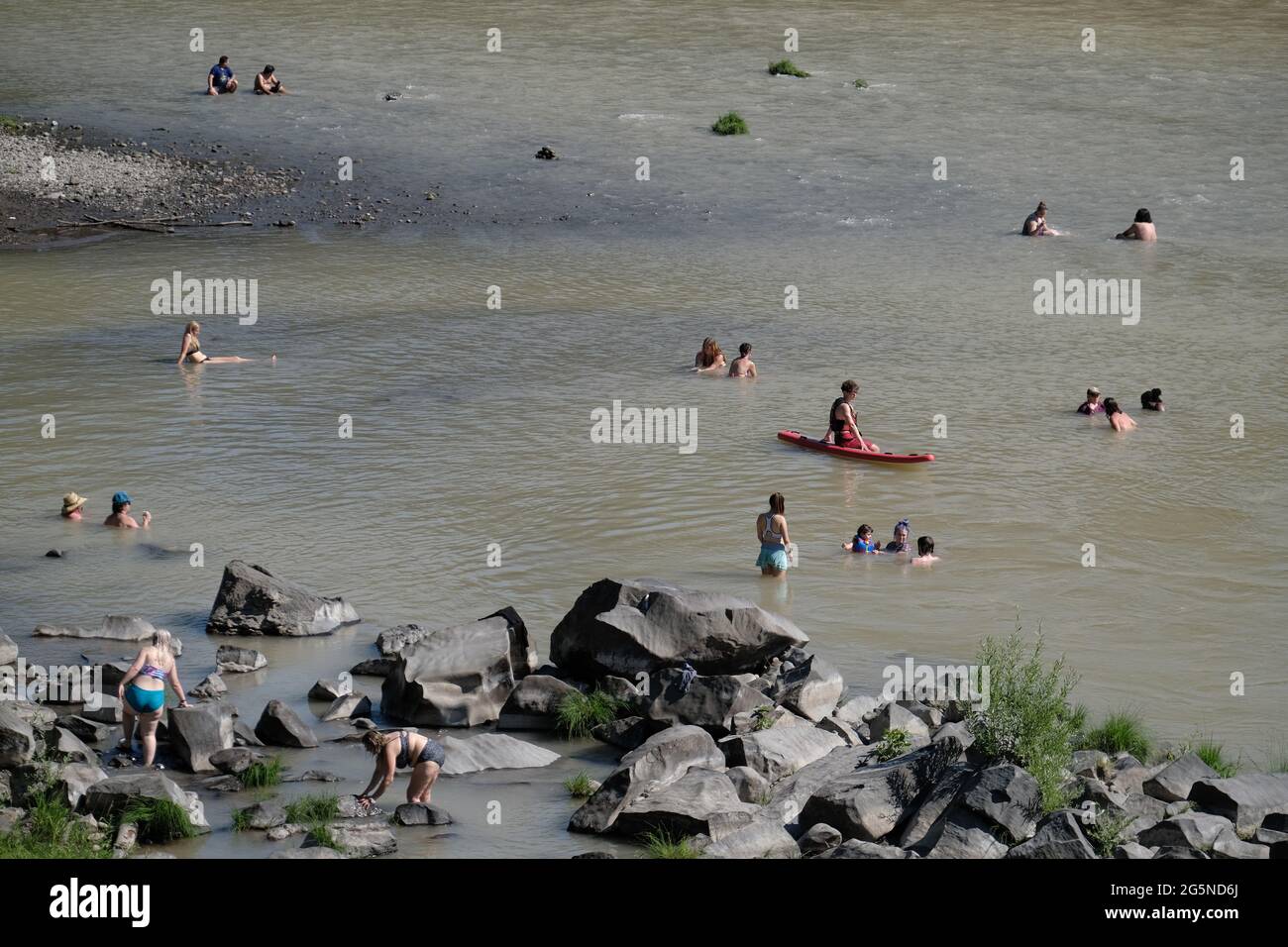 A lifeguard monitors the water as people cool off in the Sandy River by