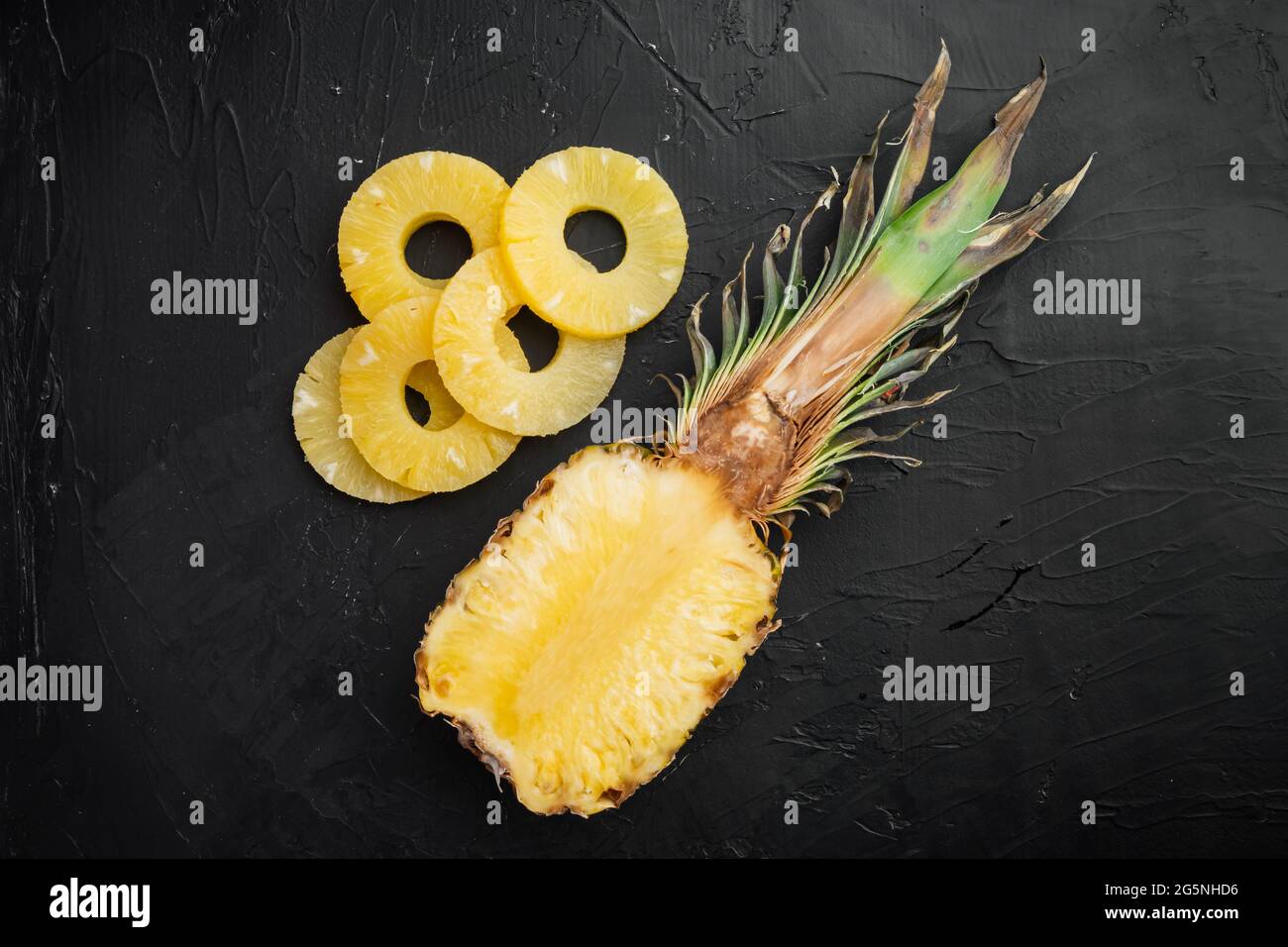 Sliced pineapple set, on black dark stone table background, top view flat lay Stock Photo